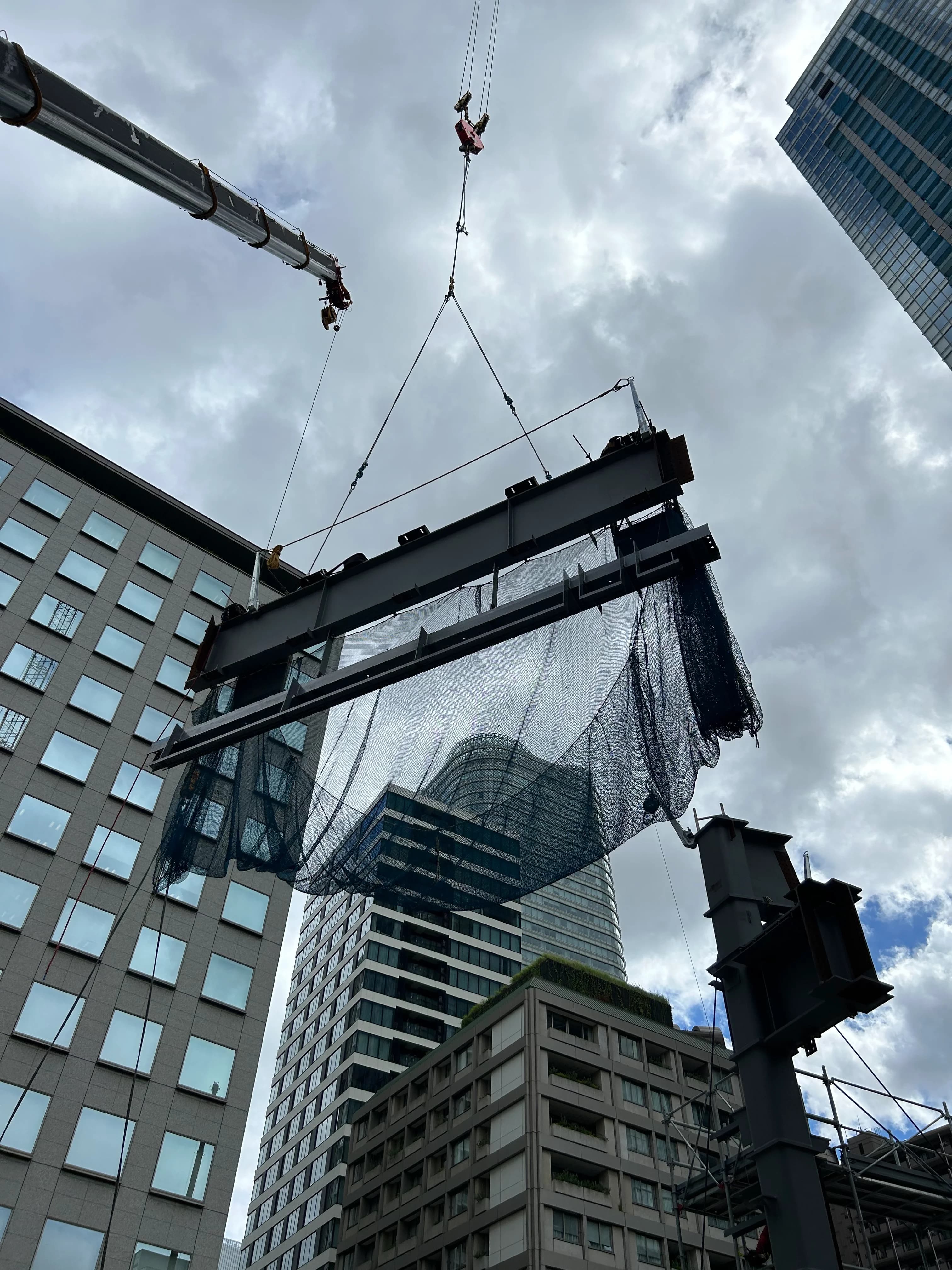 タワークレーンで鉄骨を吊り上げる建設現場